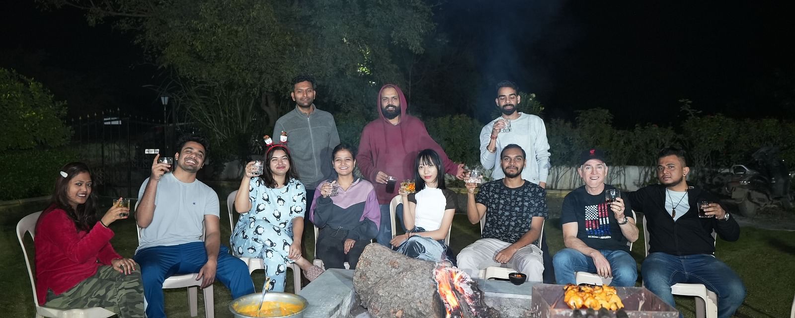 Outdoor night scene of a hostel gathering with guests enjoying a barbecue | Diamond Parks, Pune 