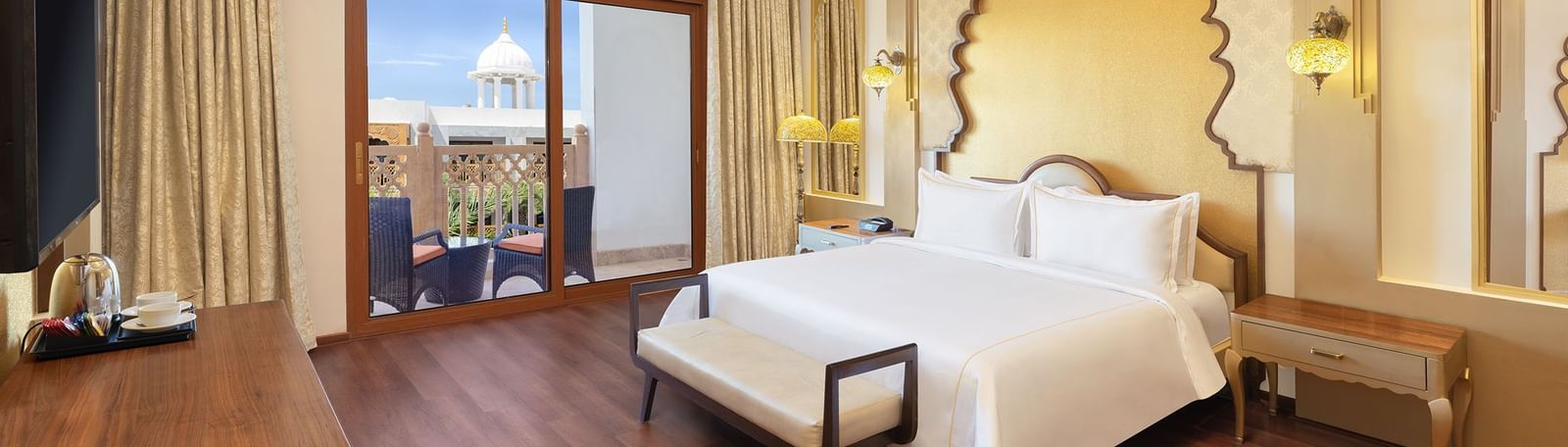 Spacious bedroom featuring crisp white linens and wide windows overlooking scenic views – Kaldan Samudra, one of the top resorts near Mahabalipuram