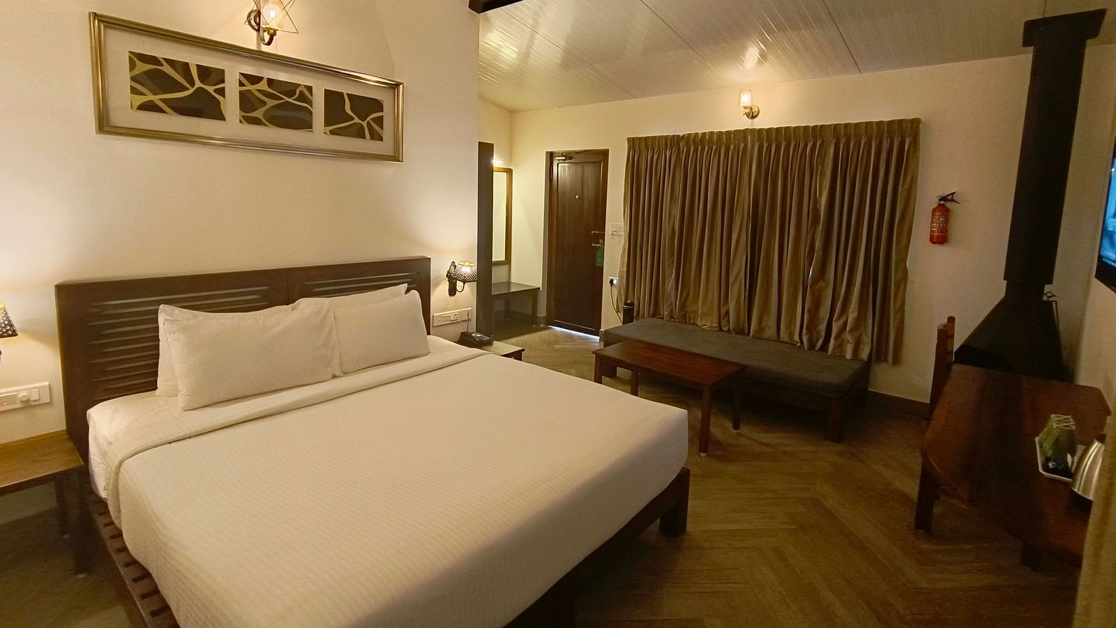 Classic room with a queen-size bed, cozy seating area, and warm lighting.