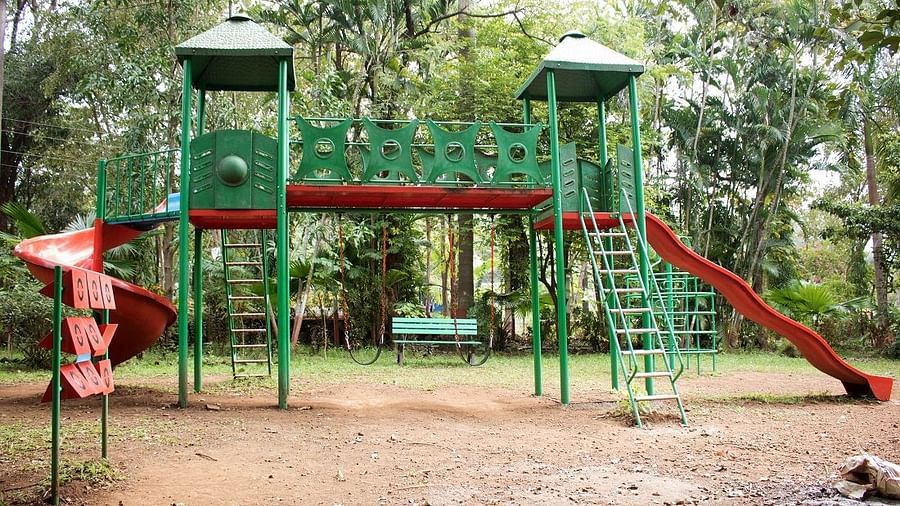 Kids Play Area - Sajan - a slide with green stairs and red body swirling down to touch the ground.