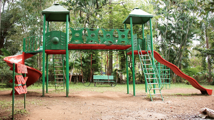 Kids Play Area - Sajan - a slide with green stairs and red body swirling down to touch the ground.