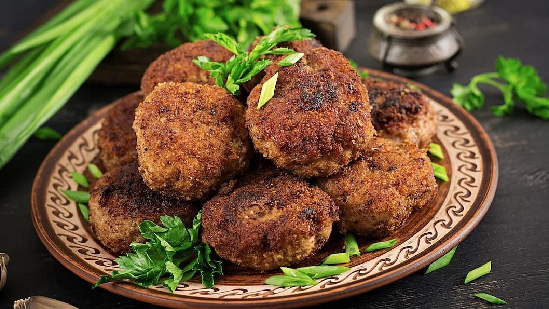 A plate of fried cutlets garnished with herbs