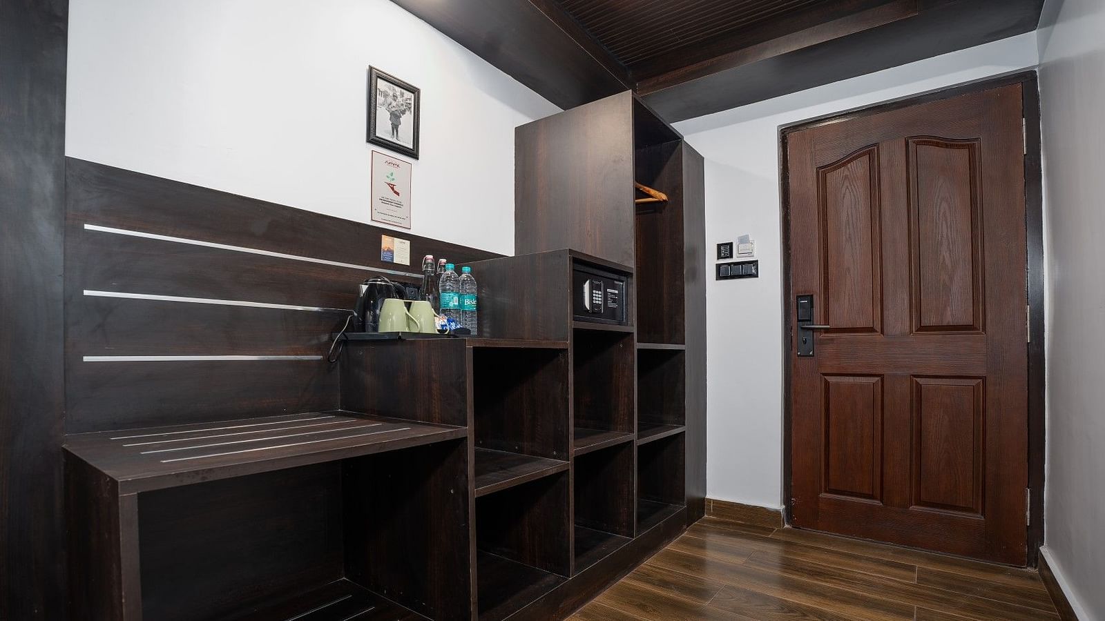 Image of the entrance of the room with a wardrobe on one side along with a table.