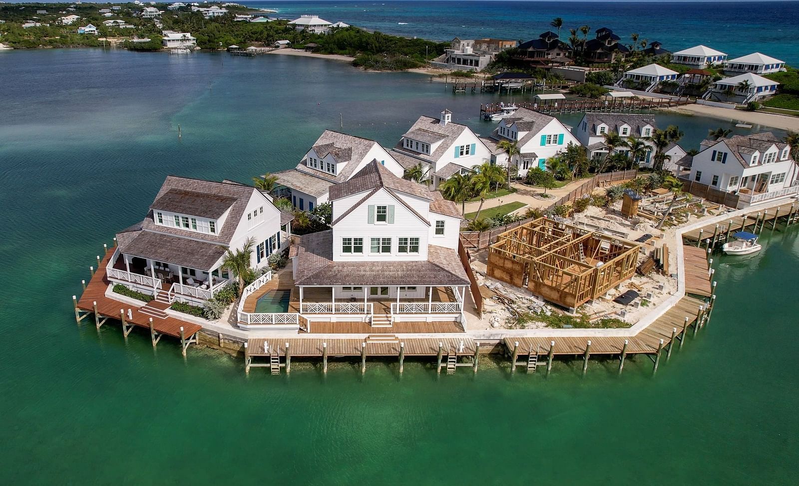 Overwater villas stretch along a calm shoreline, surrounded by a marina in a resort setting | Abaco Inn