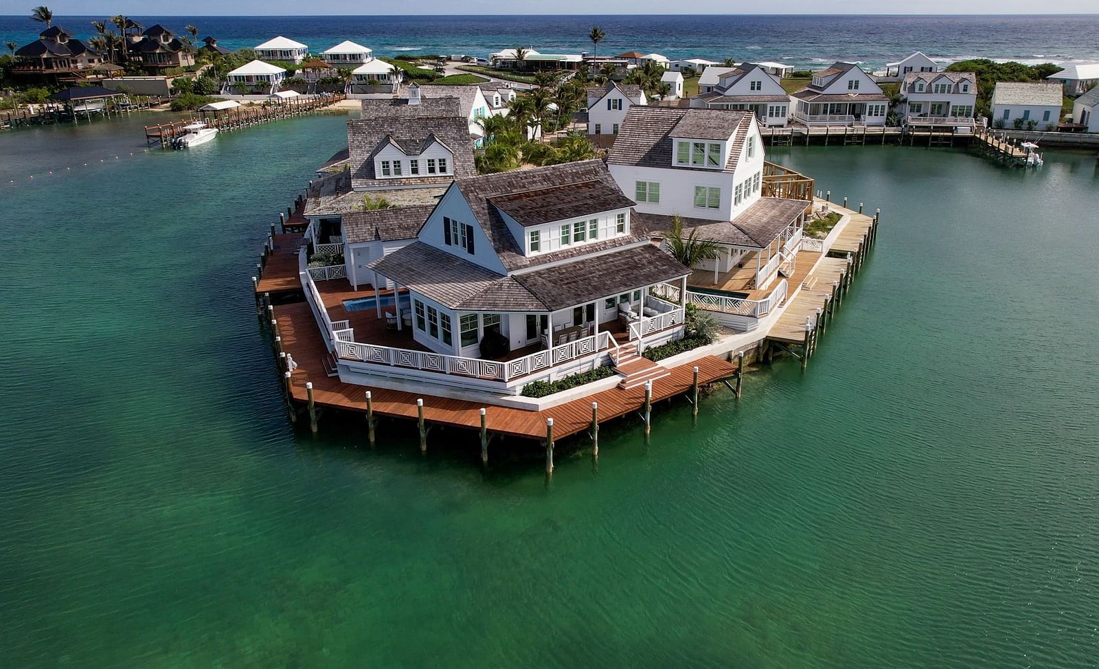 Round building on stilts in the water, connected to shore by a bridge, seen from above in a clear aerial shot | Abaco Inn