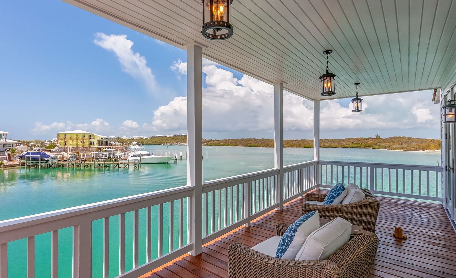 A wooden balcony with comfortable chairs with a view of the sea at Abaco Inn.