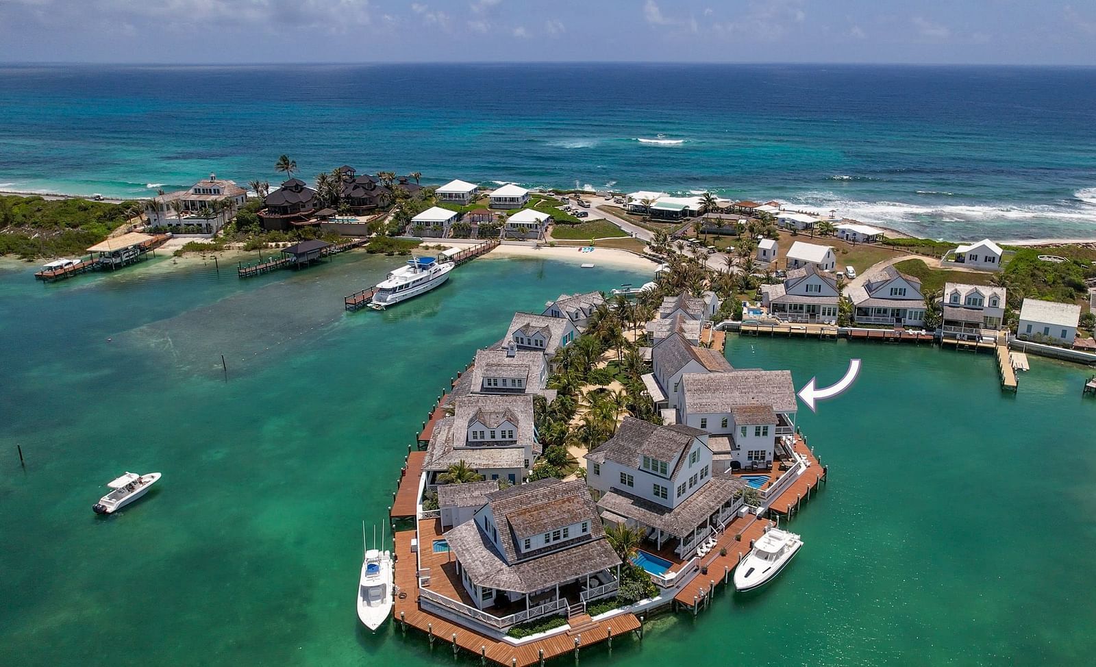 Aerial view of luxurious waterfront houses with private docs on the sea and boats docked nearby at Abaco Inn.