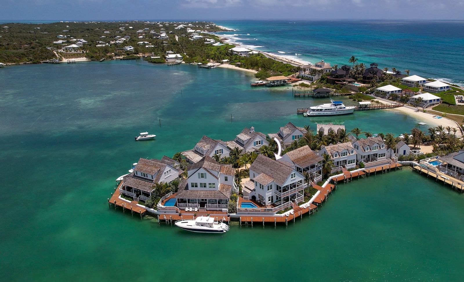 A luxurious waterfront houses with private docs on the sea and a boat docked nearby at Abaco Inn.