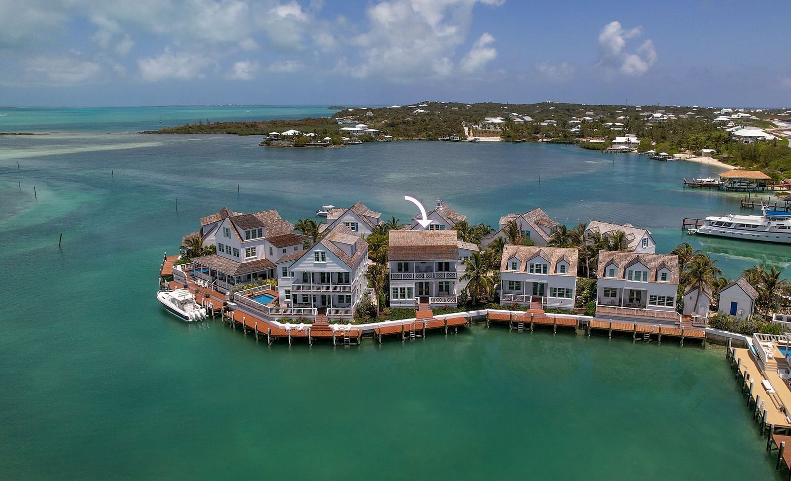 Aerial view of luxurious waterfront houses with private docs, and a boat docked nearby at Abaco Inn.