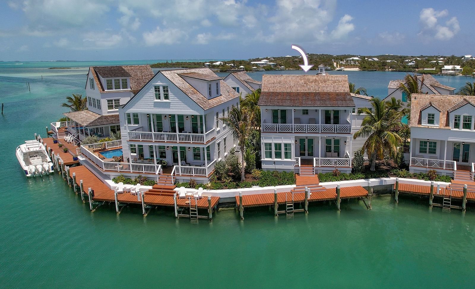 Aerial view of luxurious waterfront houses with private docs, a boat docked nearby at Abaco Inn.