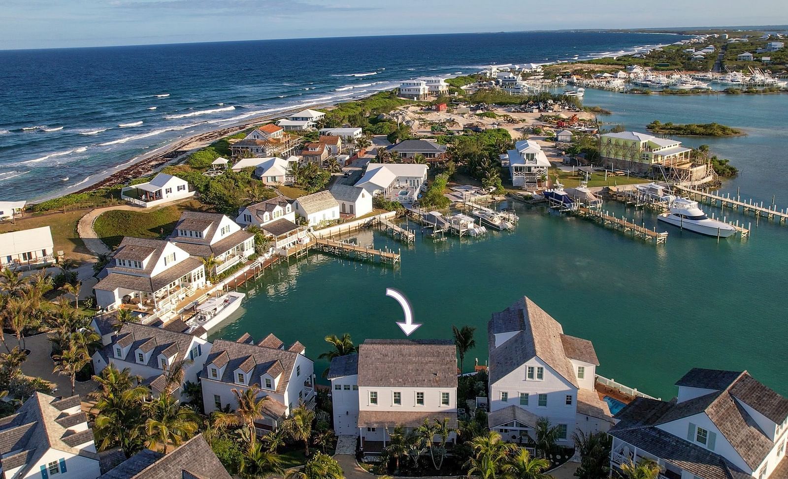 Aerial view of luxurious waterfront houses with private docs, swimming pools and a boat docked nearby at Abaco Inn.