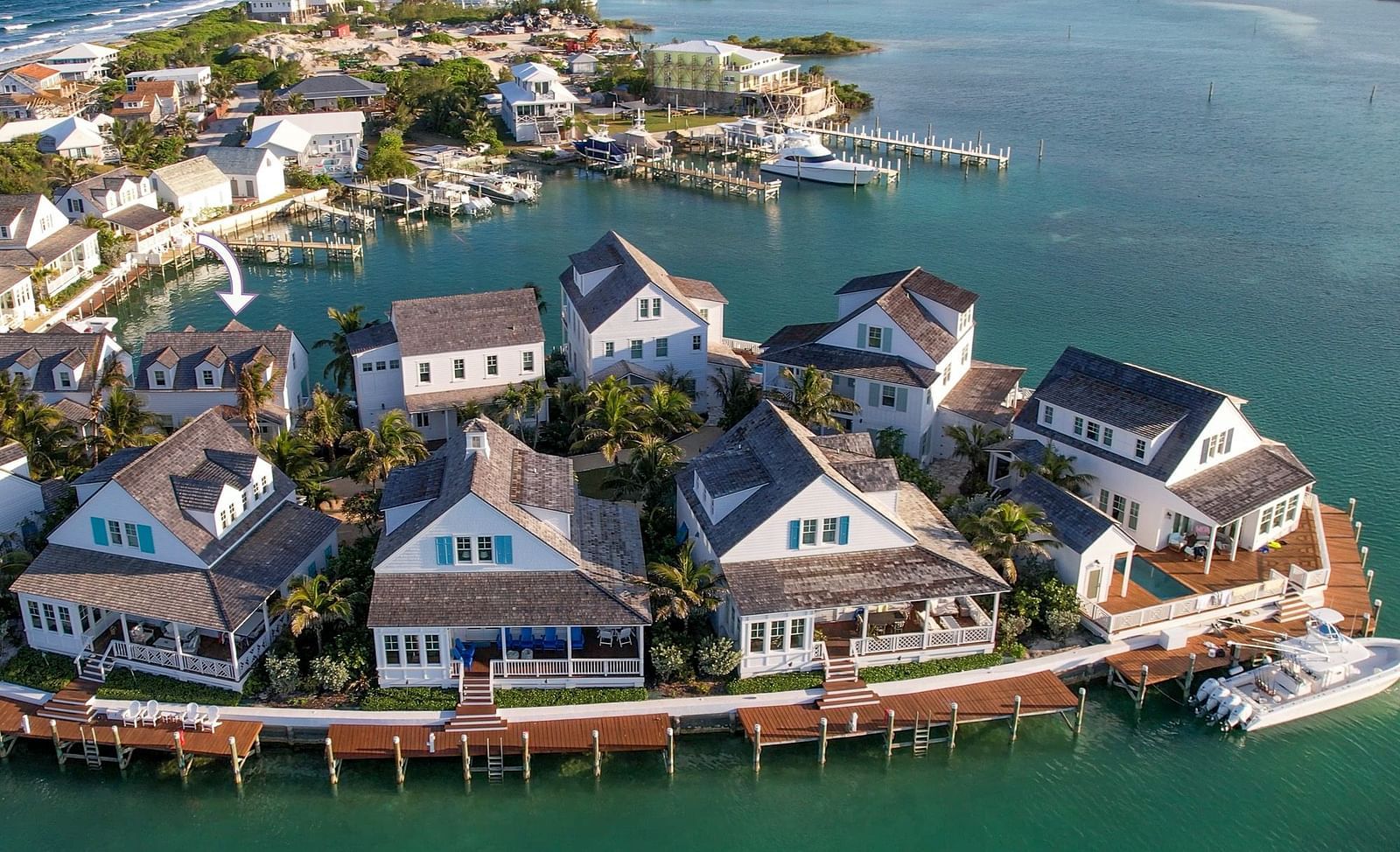 Aerial view of luxurious waterfront houses with private docs and a boat docked nearby at Abaco Inn.