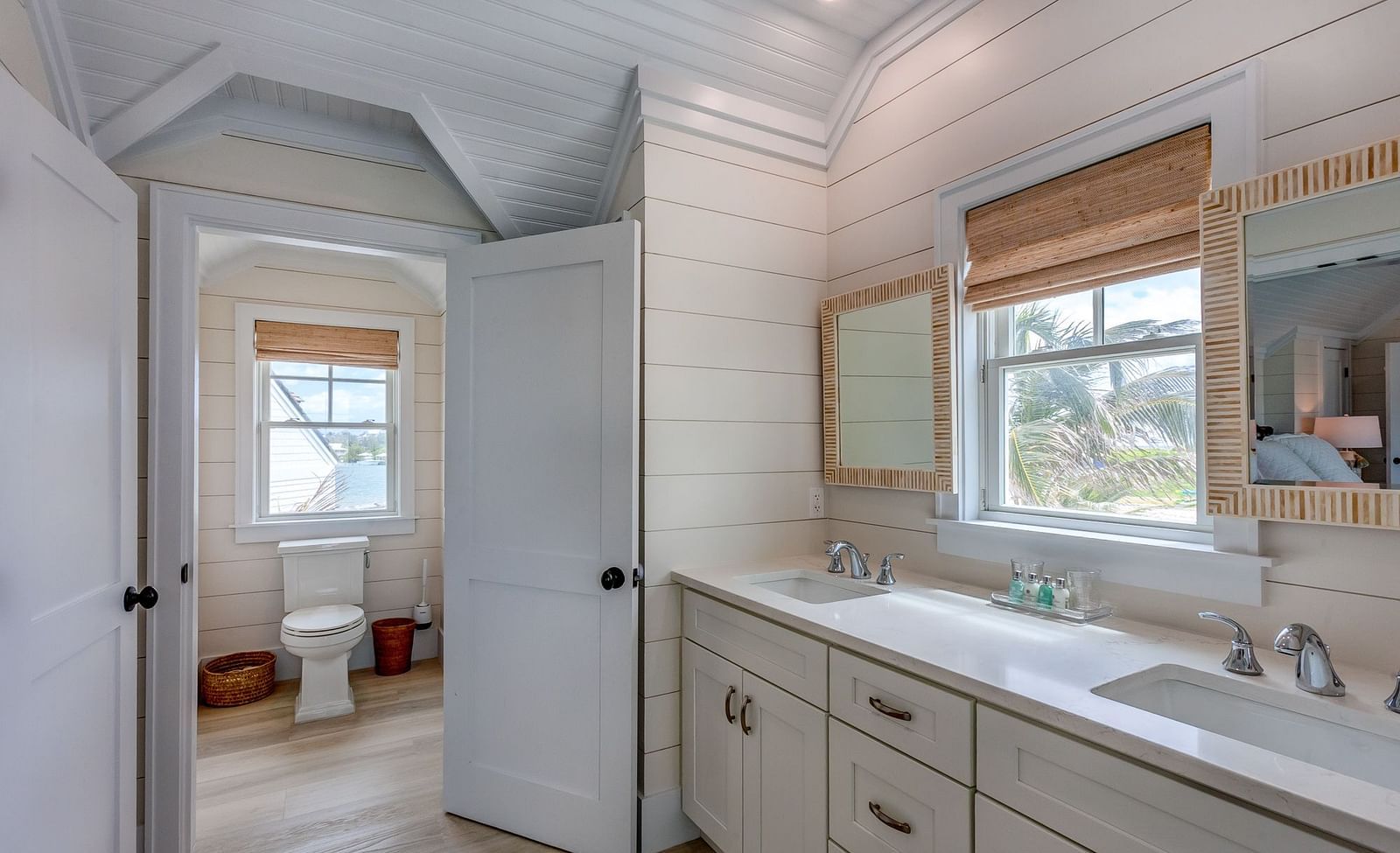 Bathroom with a vanity, white cabinets, and a glass-enclosed shower | Abaco Inn