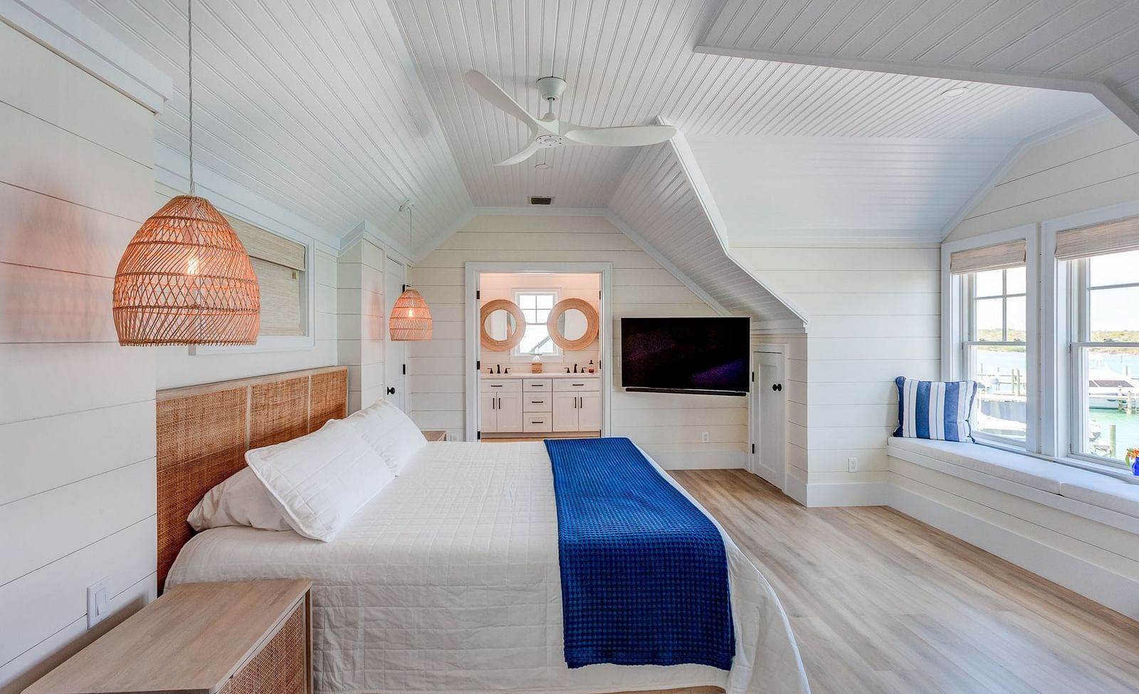 Bedroom with sloped ceiling, wooden furniture, and a TV | Abaco Inn