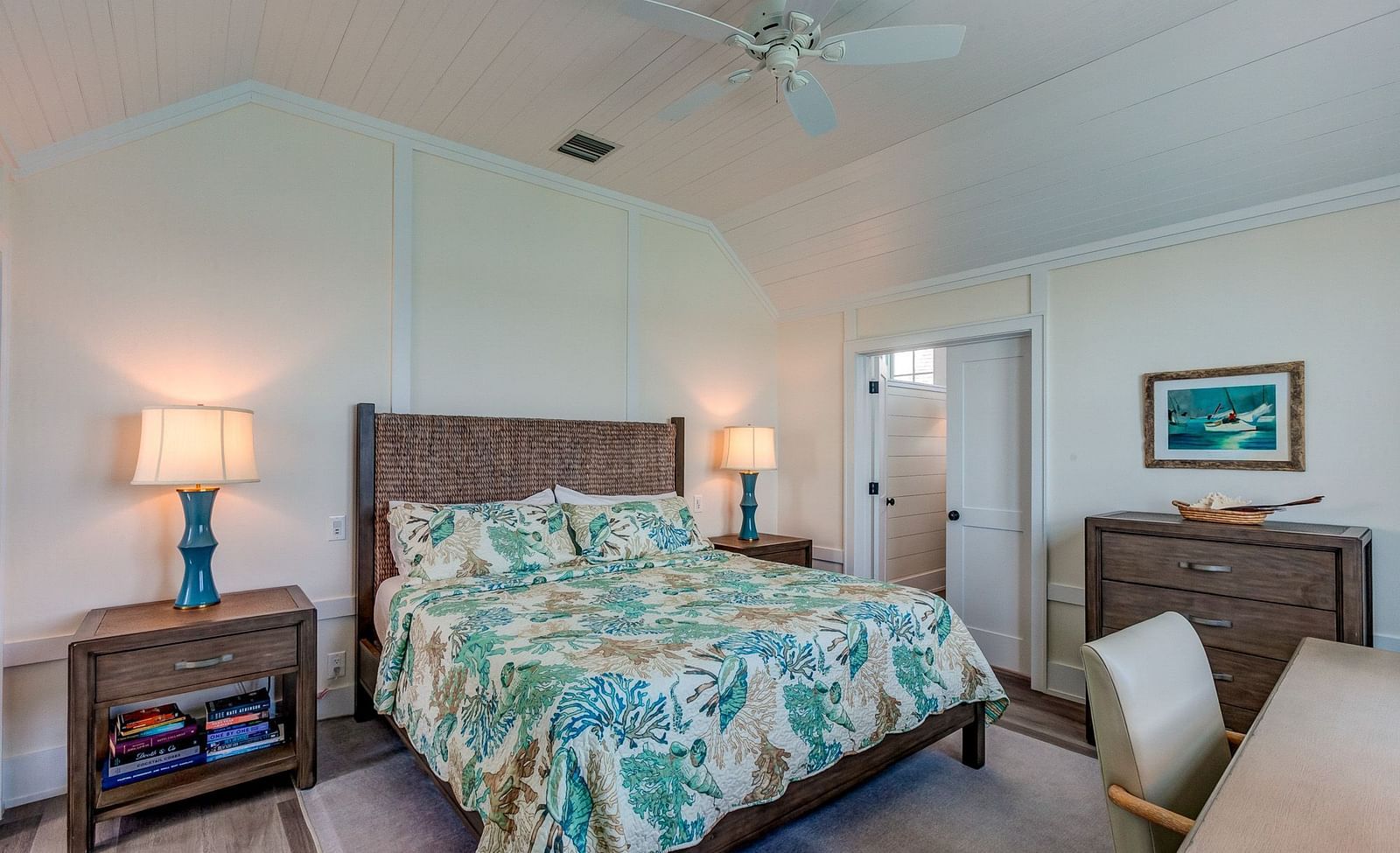 Bedroom with a patterned bedspread, wooden furniture, and a ceiling fan | Abaco Inn