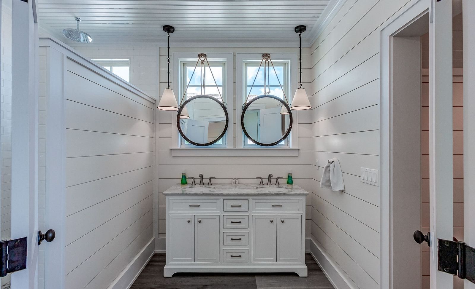 Double vanity bathroom with two round mirrors and a white countertop | Abaco Inn