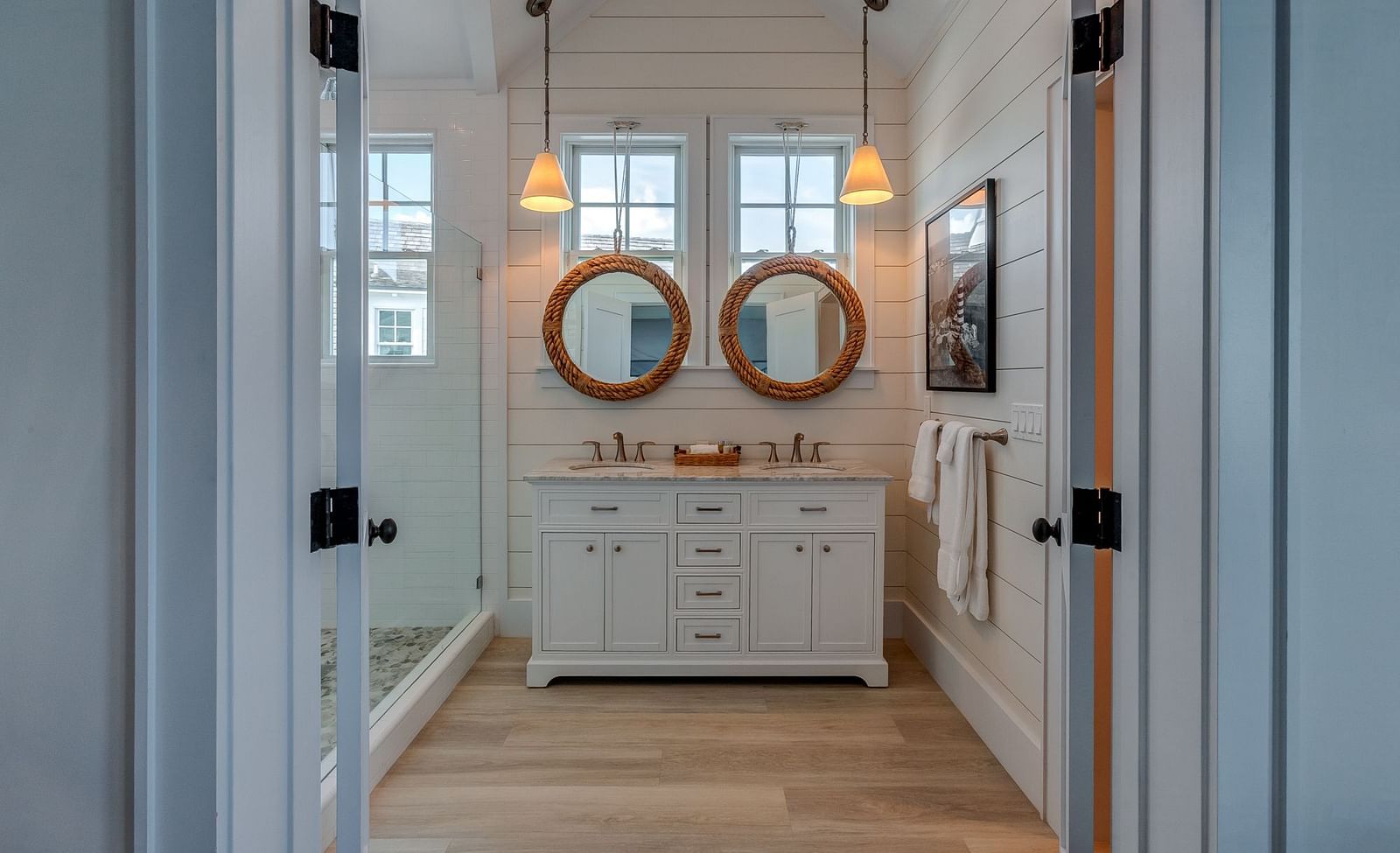 Double vanity bathroom with round mirrors and white cabinetry | Abaco Inn
