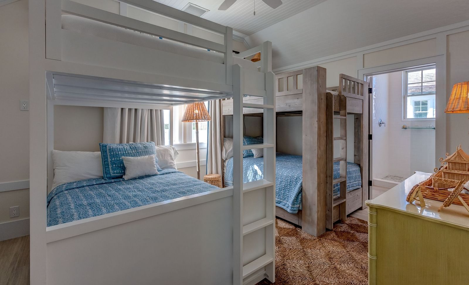 Room with white bunk beds, a green couch, and wooden flooring | Abaco Inn