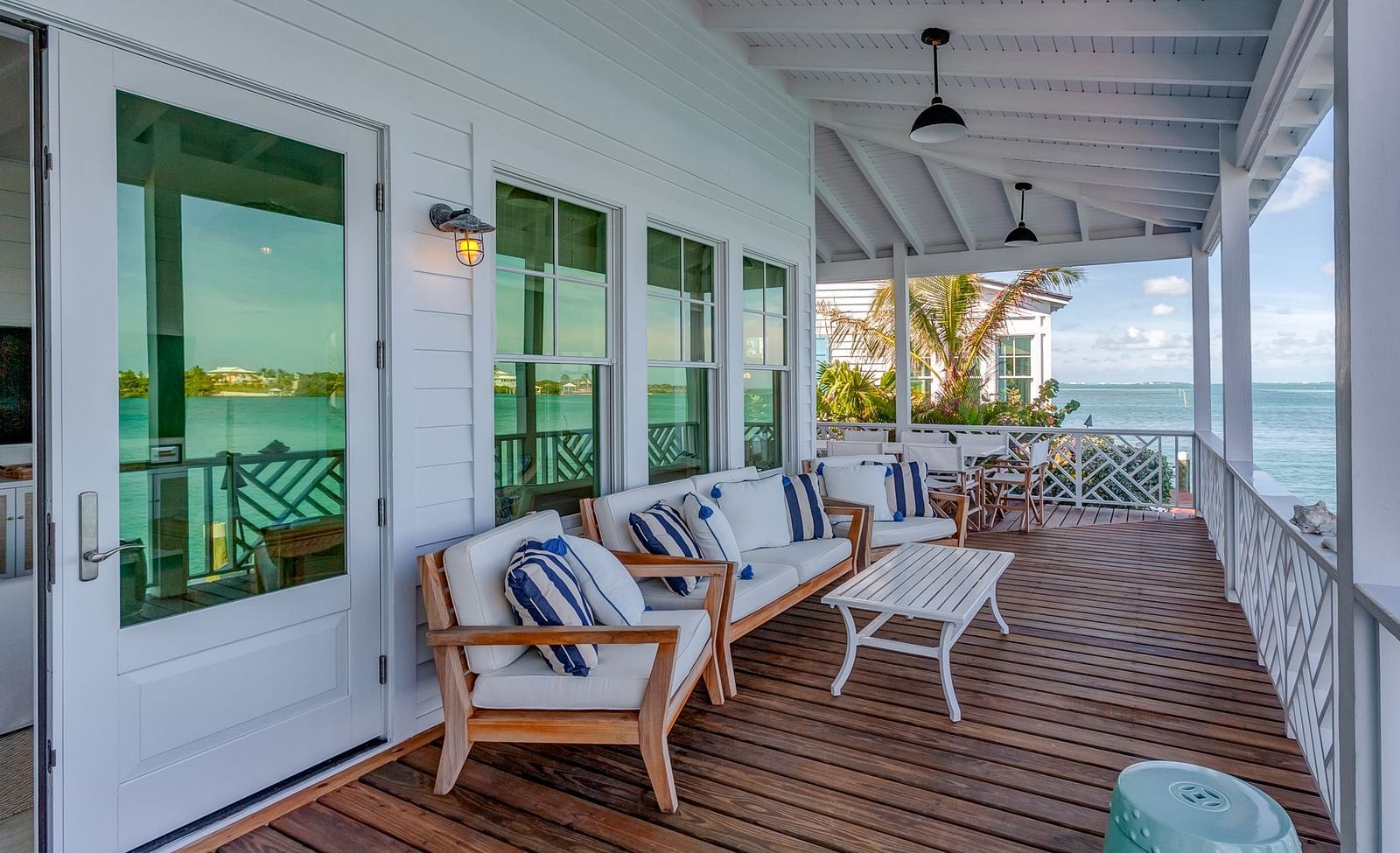 Covered patio with cushioned seating facing the ocean view | Abaco Inn