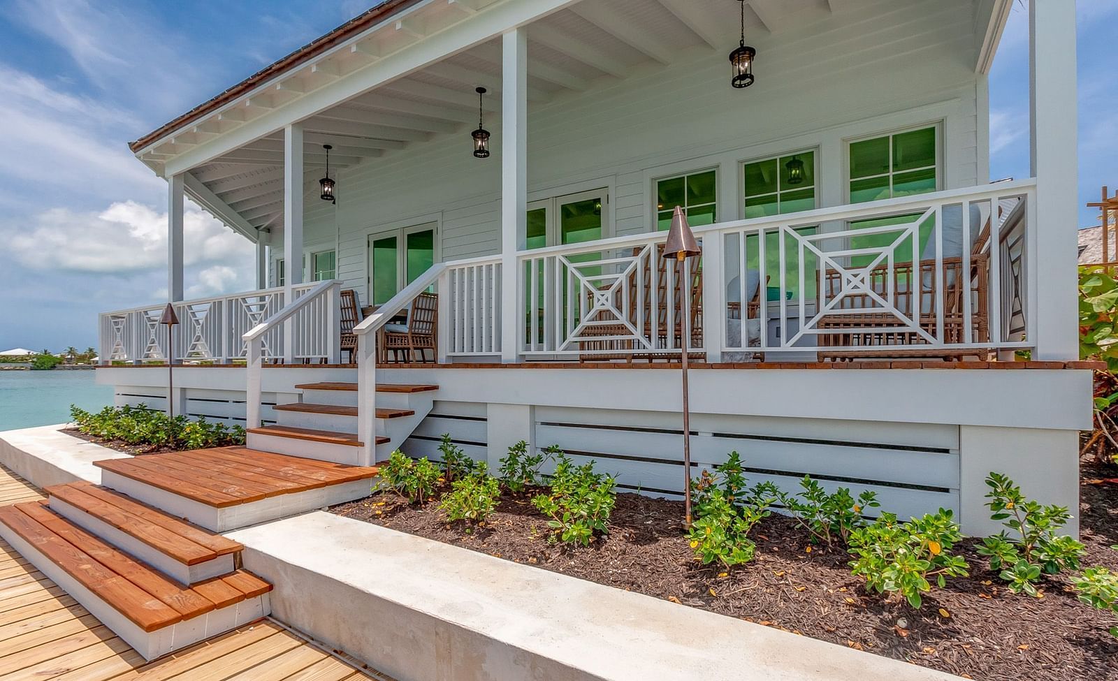 Exterior of a coastal villa with a wraparound porch and garden | Abaco Inn