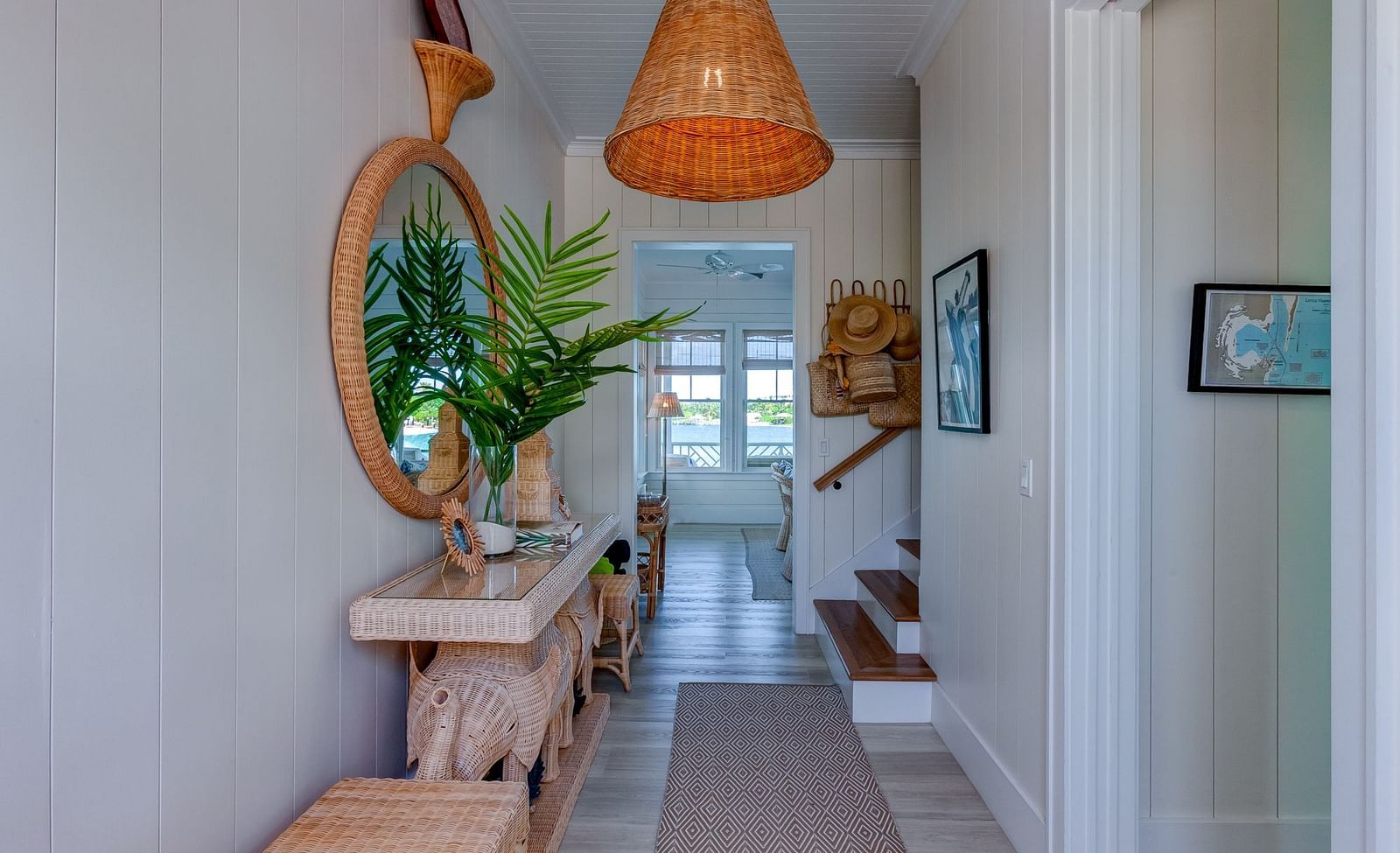 Hallway with a wooden bench, potted plant, and a hanging wicker light fixture | Abaco Inn