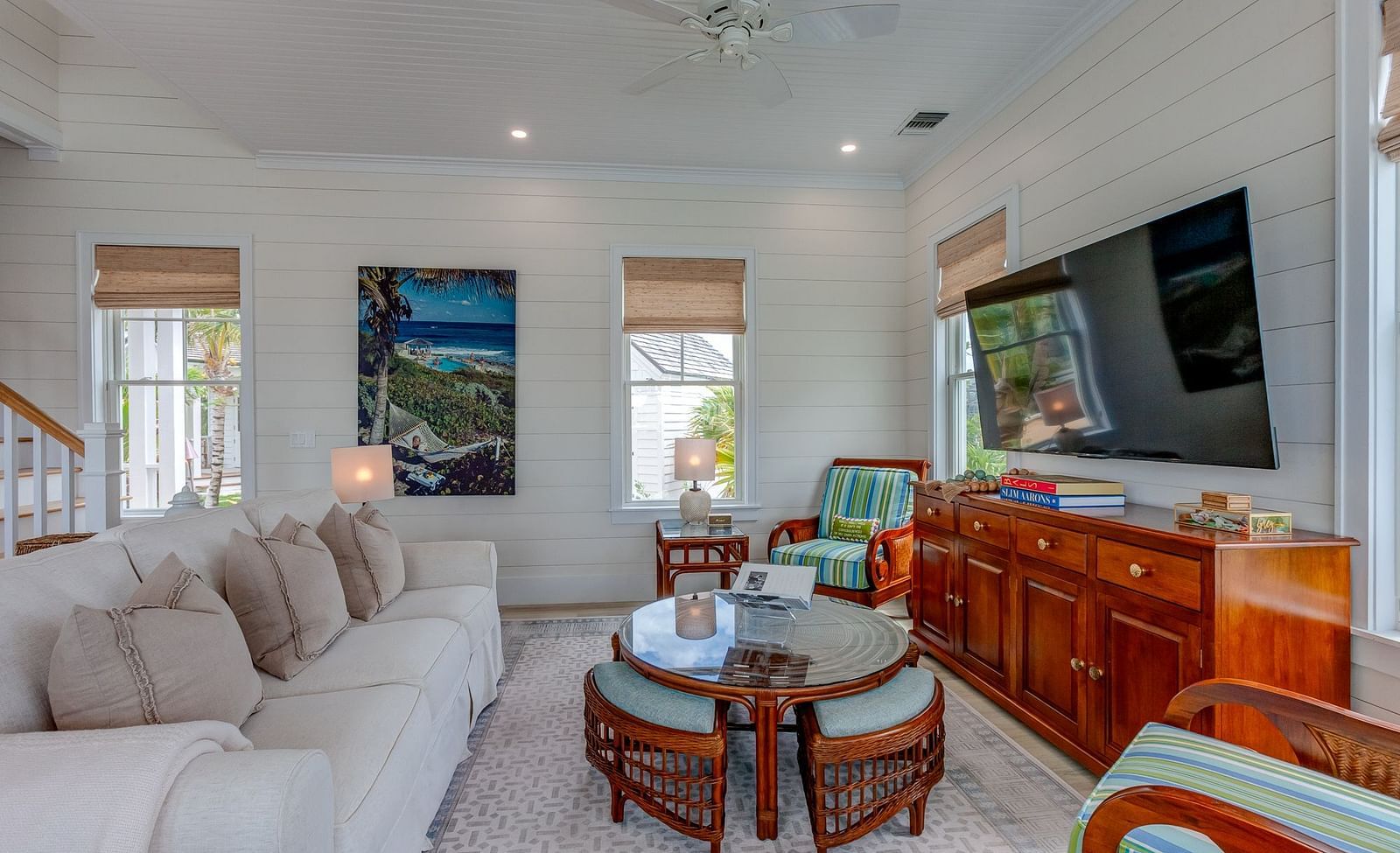Living room with a sectional sofa, wooden furniture, and wall-mounted TV | Abaco Inn