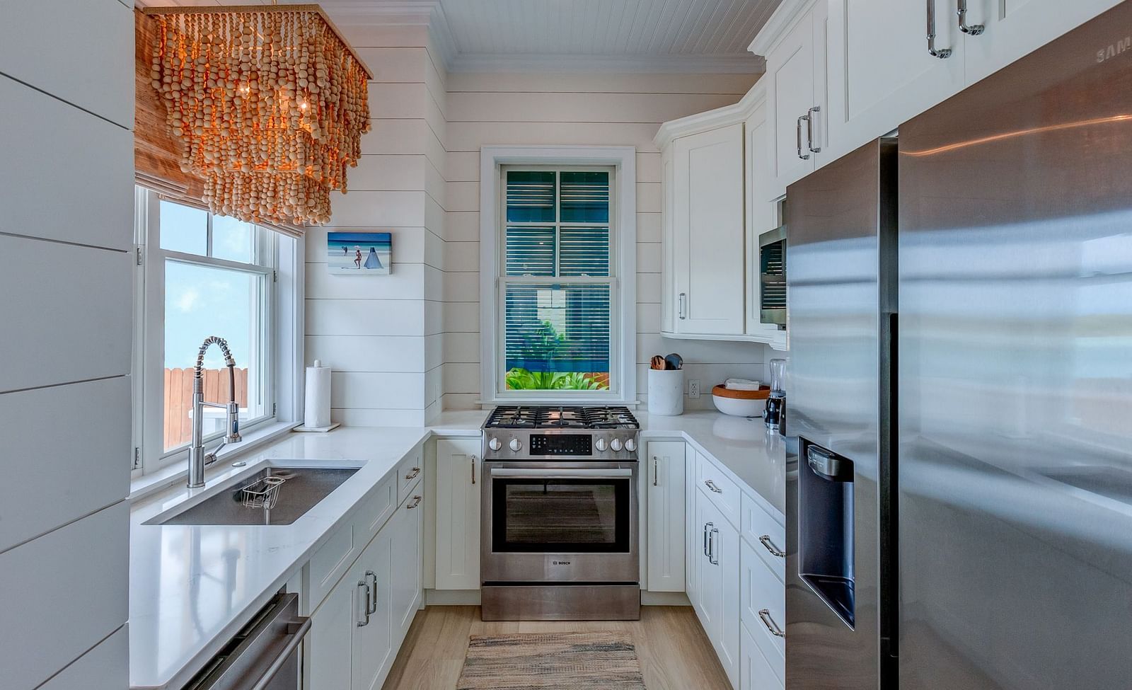 Modern kitchen with white cabinetry, stainless steel appliances, and a window view | Abaco Inn