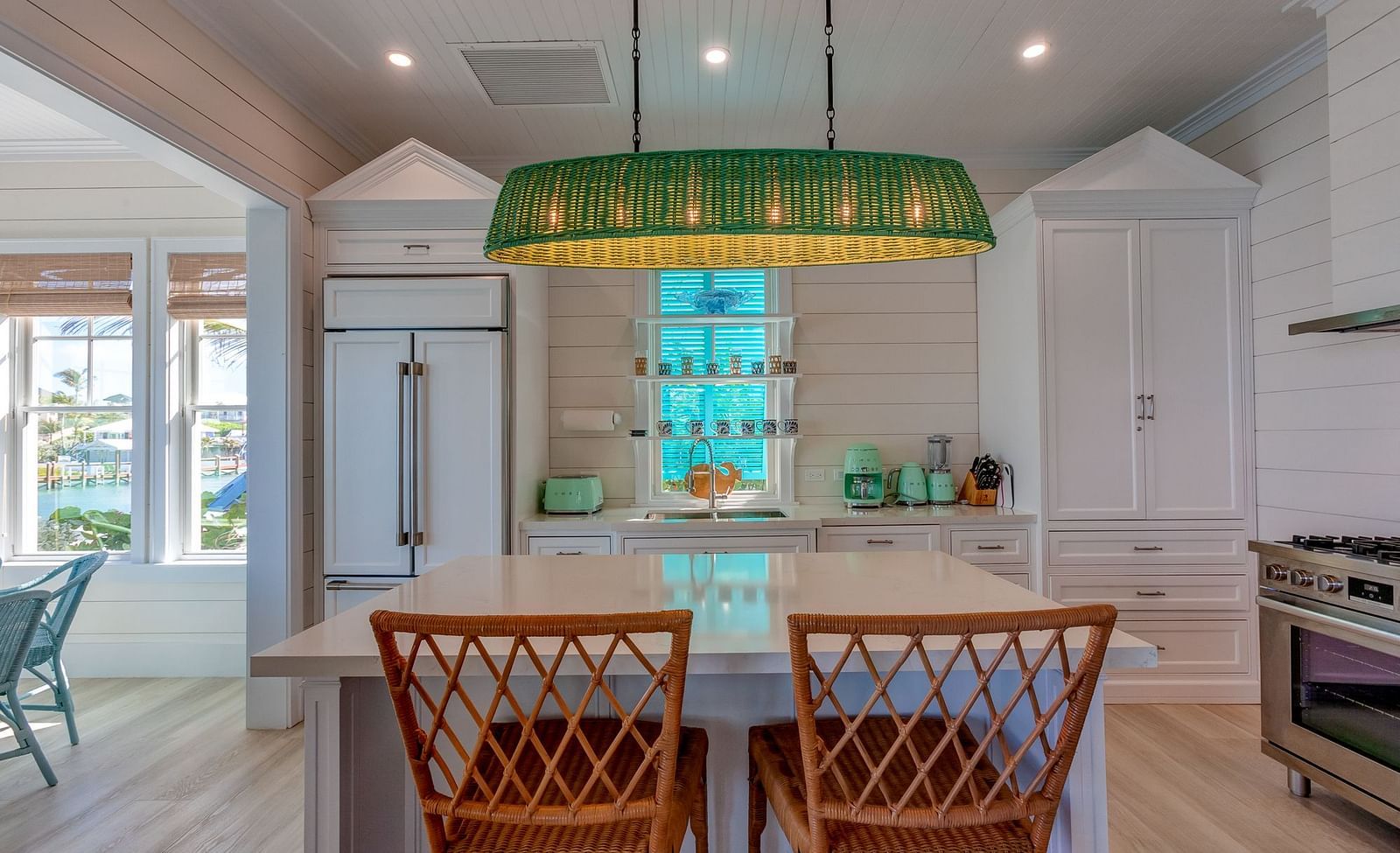 Kitchen with a dining table, green pendant light, and white cabinetry | Abaco Inn