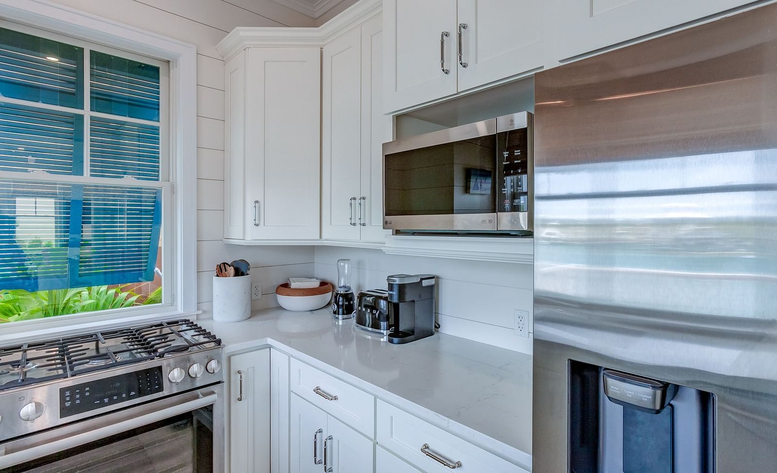Kitchen with white cabinetry, a stainless steel fridge, and a stove | Abaco Inn