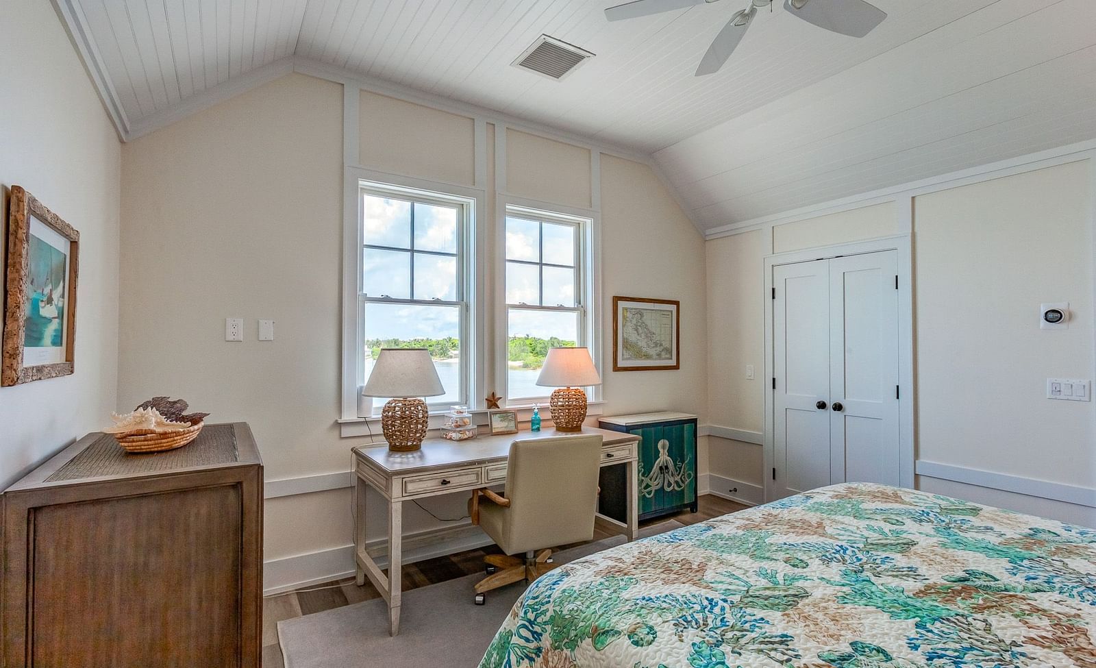 Bedroom with a floral bedspread, white walls, and a window letting in natural light | Abaco Inn