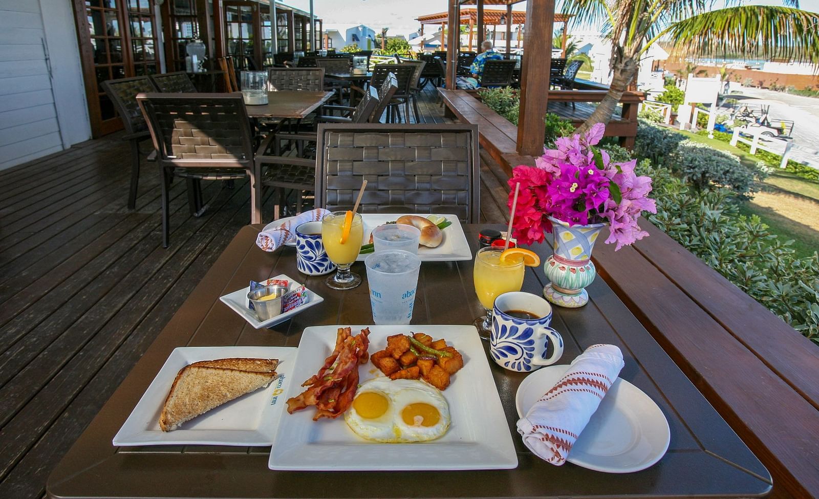 Table with breakfast plates under a shaded deck | Abaco Inn