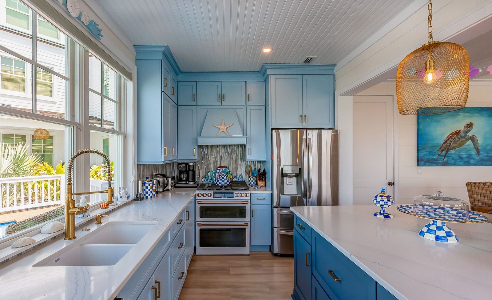 Bright, Blue and White themed kitchen with cupboards and windows that overlooks the sea at Abaco Inn.