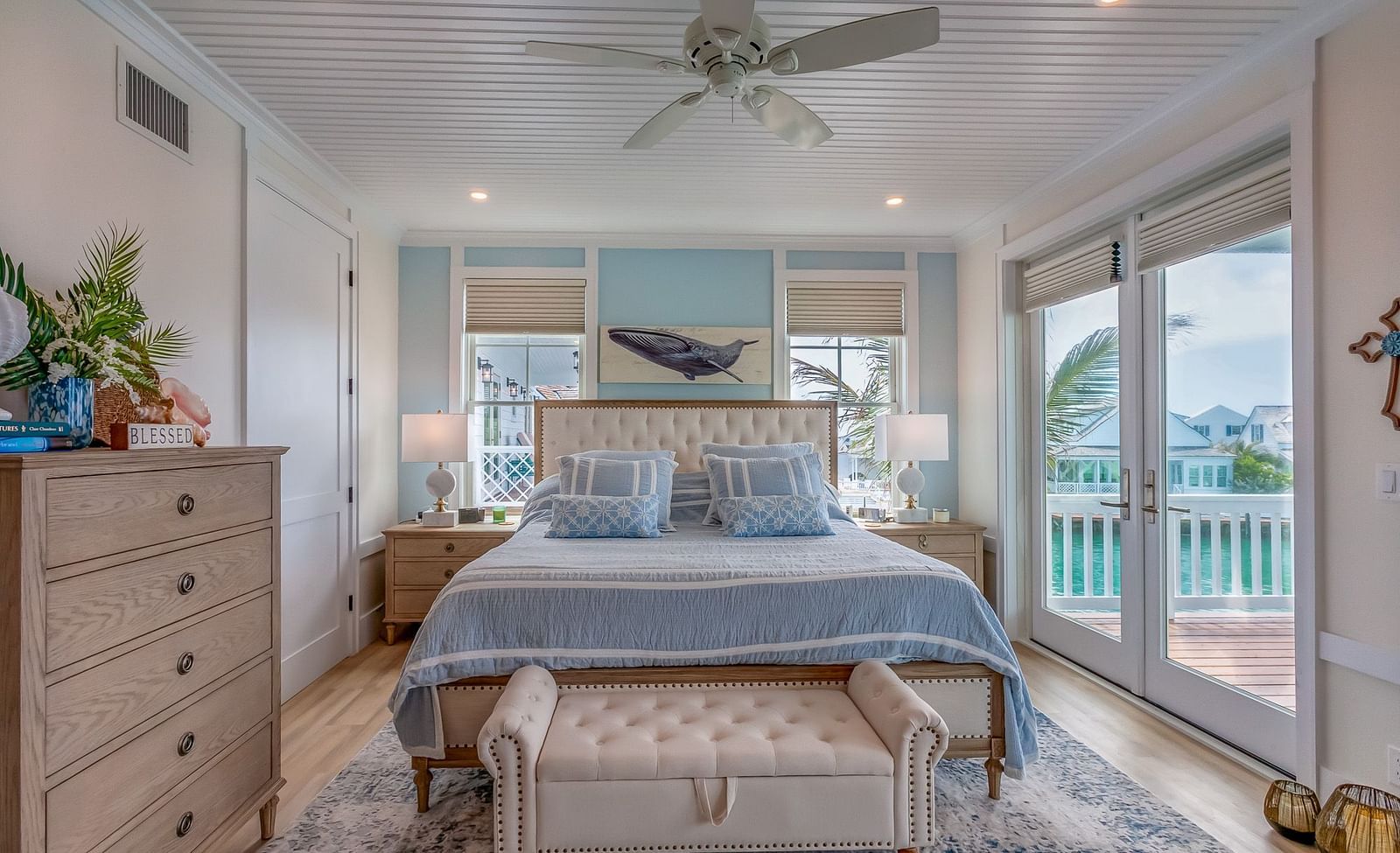 A bright and spacious bedroom with a huge bed and a sofa in the front, a cupboard, bedside table and glass doors that leads to the balcony with a sea view at Abaco Inn.