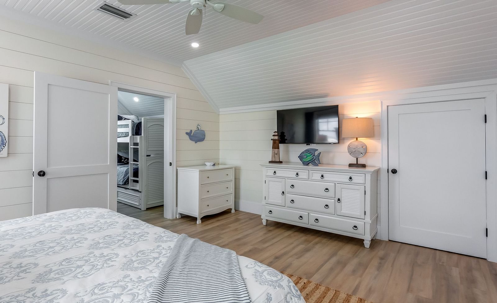 a spacious bedroom with a huge bed, cupboards, TV and wooden floor at Abaco Inn.