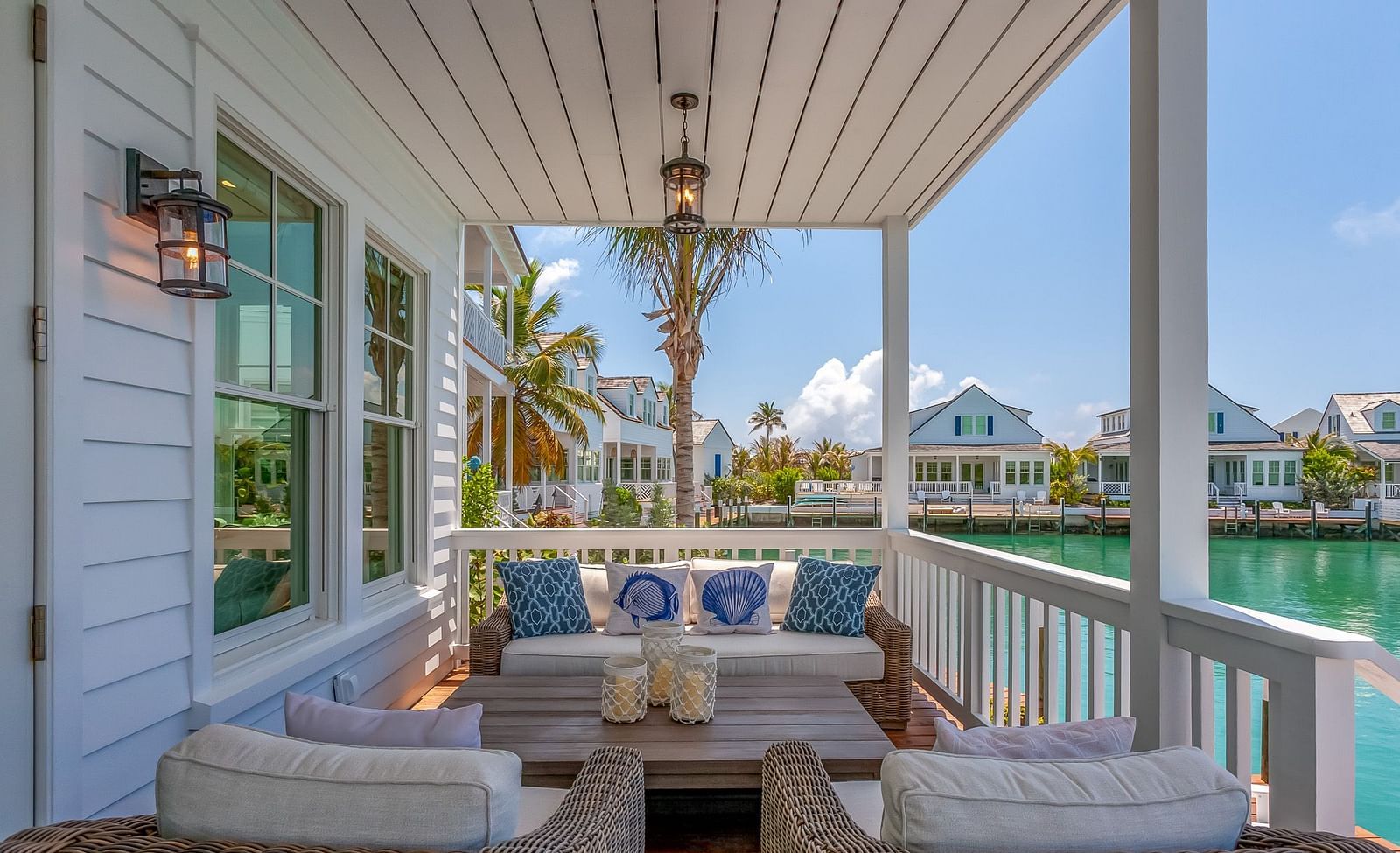 a balcony with a sitting area with comfortable chairs and table with a view of the sea at Abaco Inn.
