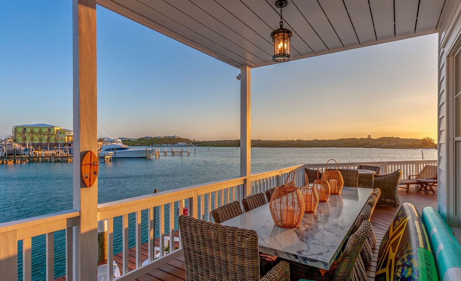 a balcony with a dining area featuring  Marble top dining table, chairs, and a sea view at  Abaco Inn.