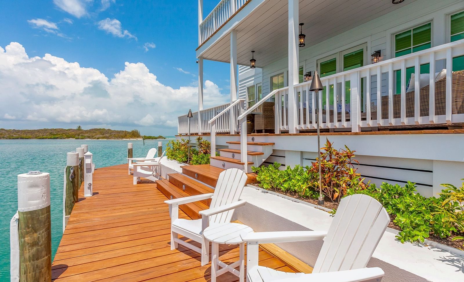 facade of the Abaco Inn with chairs on the dock and a view of the sea.