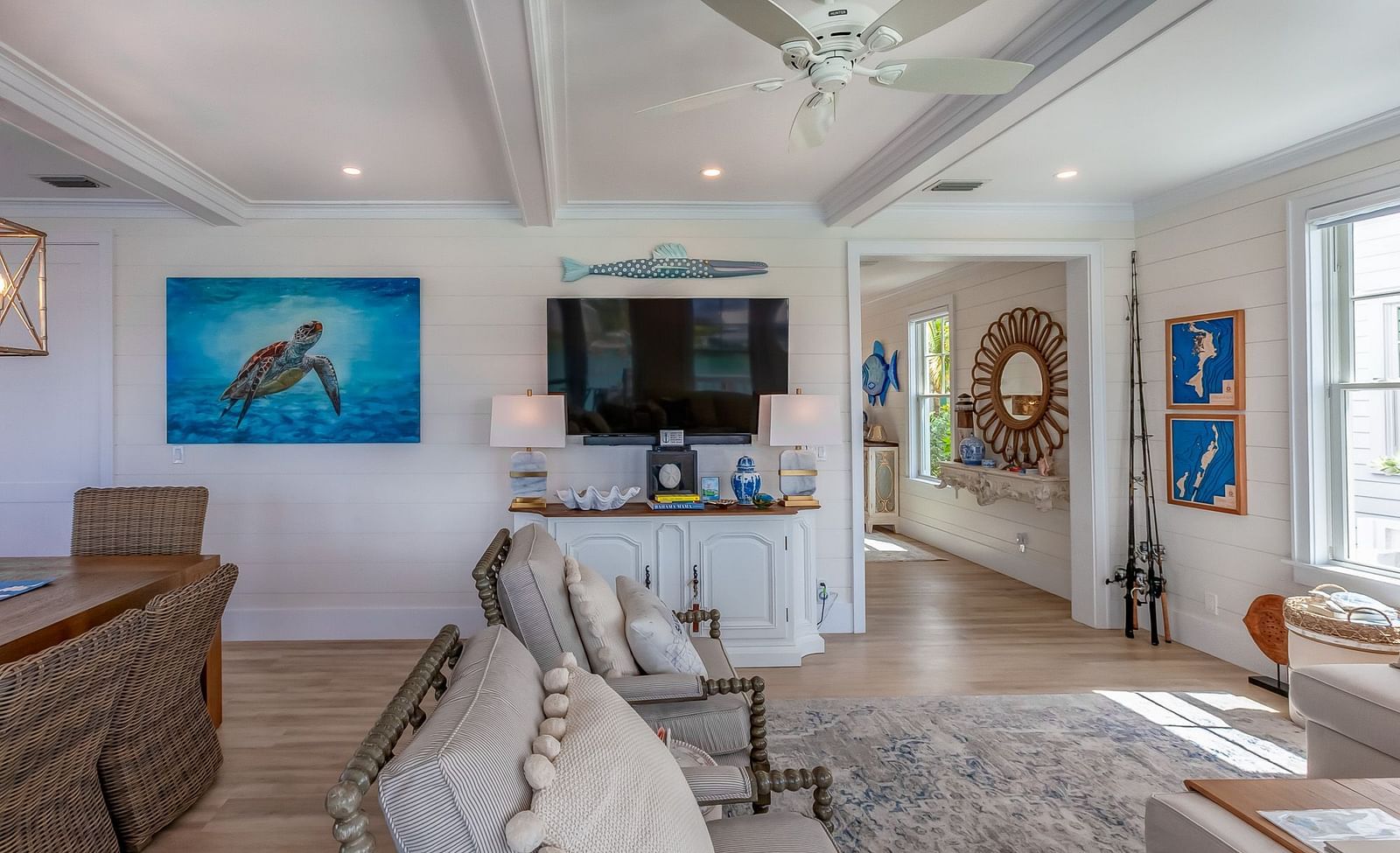 a sitting area with sofas, table, TV, cabinet and wall decors at Abaco Inn.