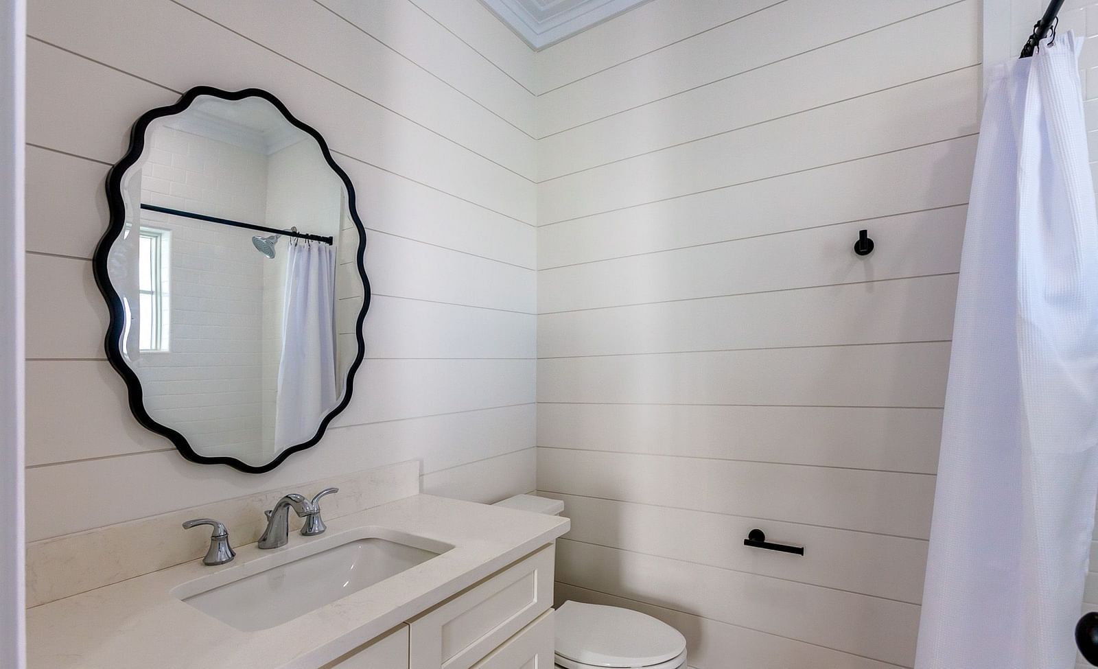 bathroom of Abaco Inn with a sink, mirror and a commode.
