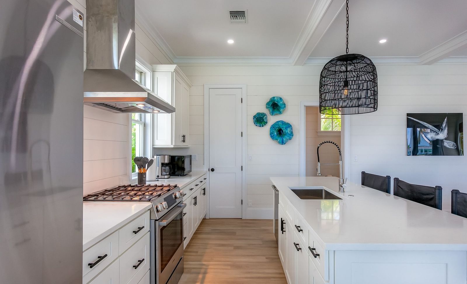 well lit Spacious kitchen with marble top table, chairs, cupboards, fridge, oven and a chimney at Abaco Inn.