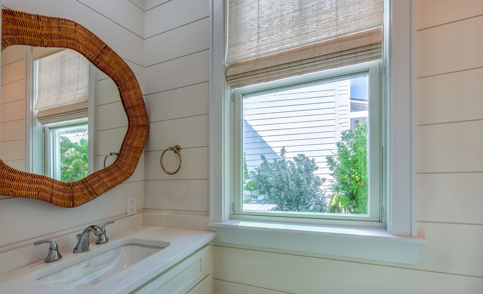 Bathroom with a sink , mirror and a window at Abaco Inn.
