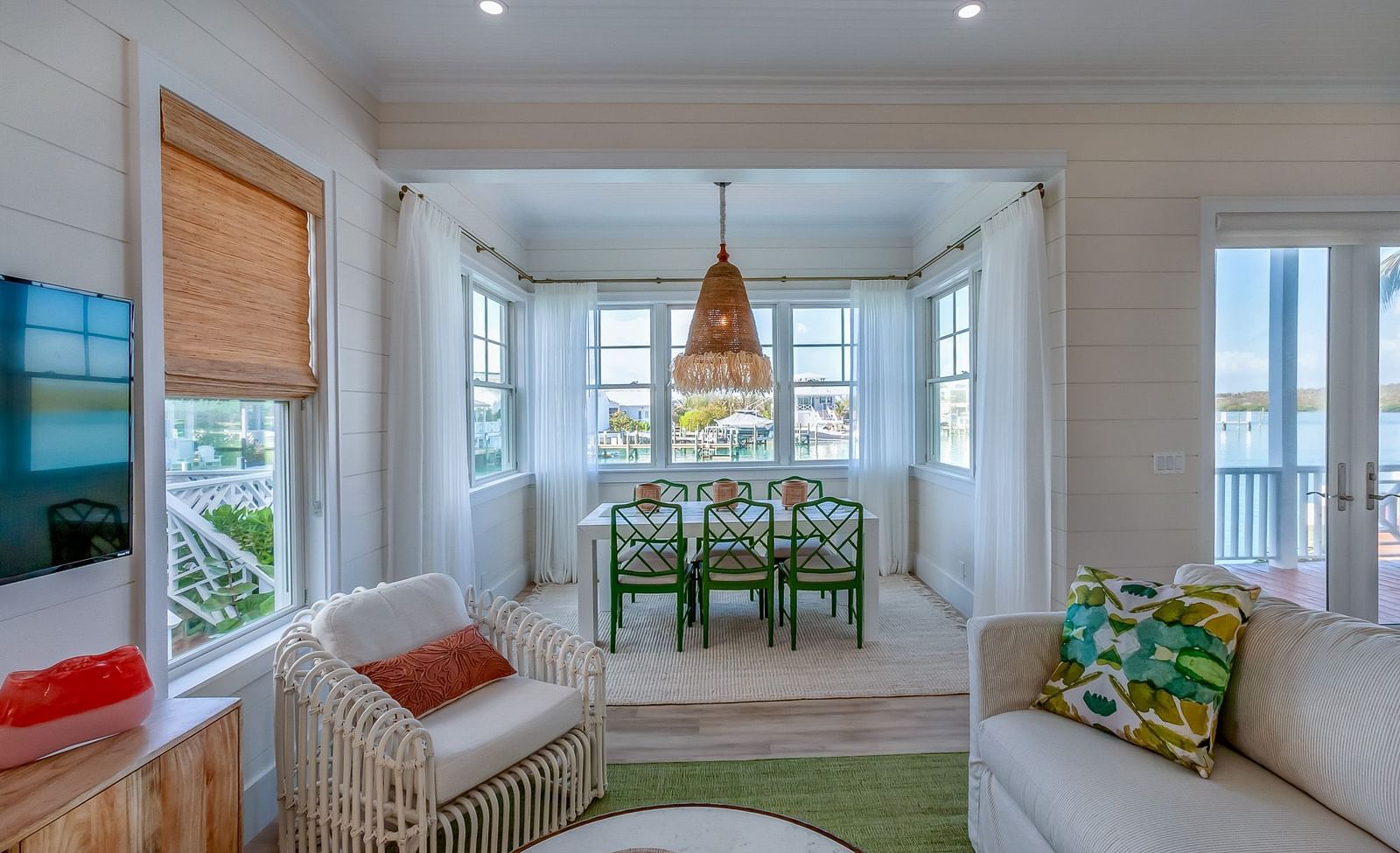 Sitting area at Abaco Inn with sofa, chairs, table, TV and windows overlooking the sea.