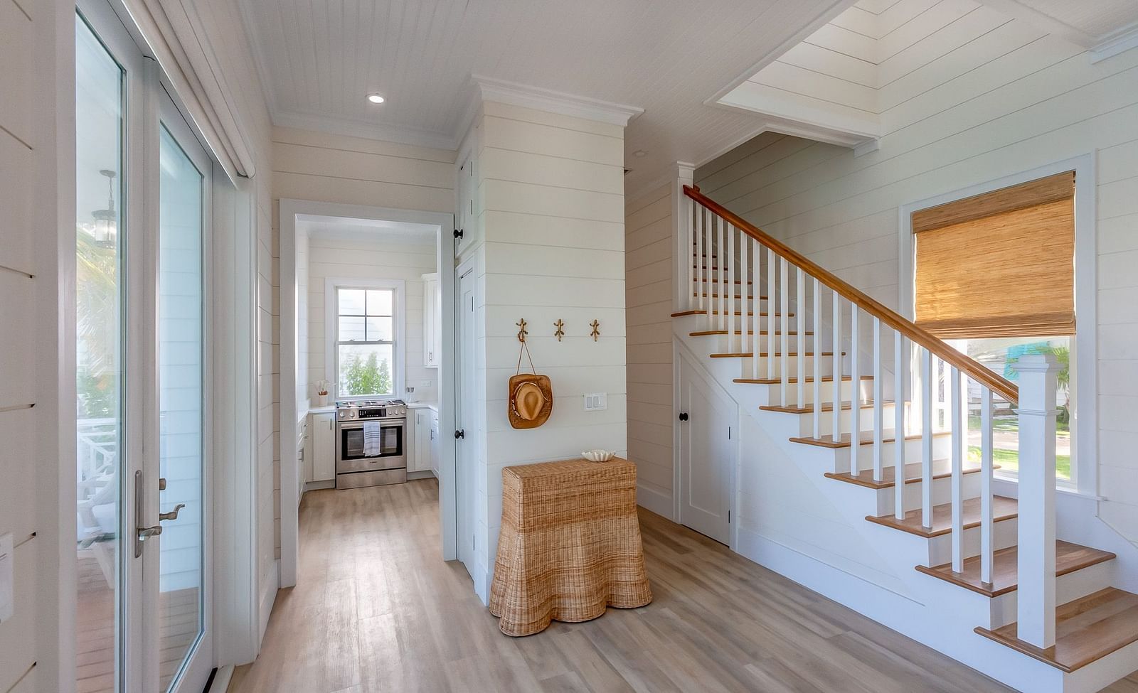 a corridor featuring a stairways, wooden floor, wall decors, and a glass door leading to the dock at Abaco Inn.