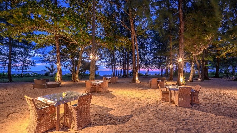 image featuring scattered open air dining arrangements on a late evening - Maikhao Dream Villa Resort & Spa, Phuket 
