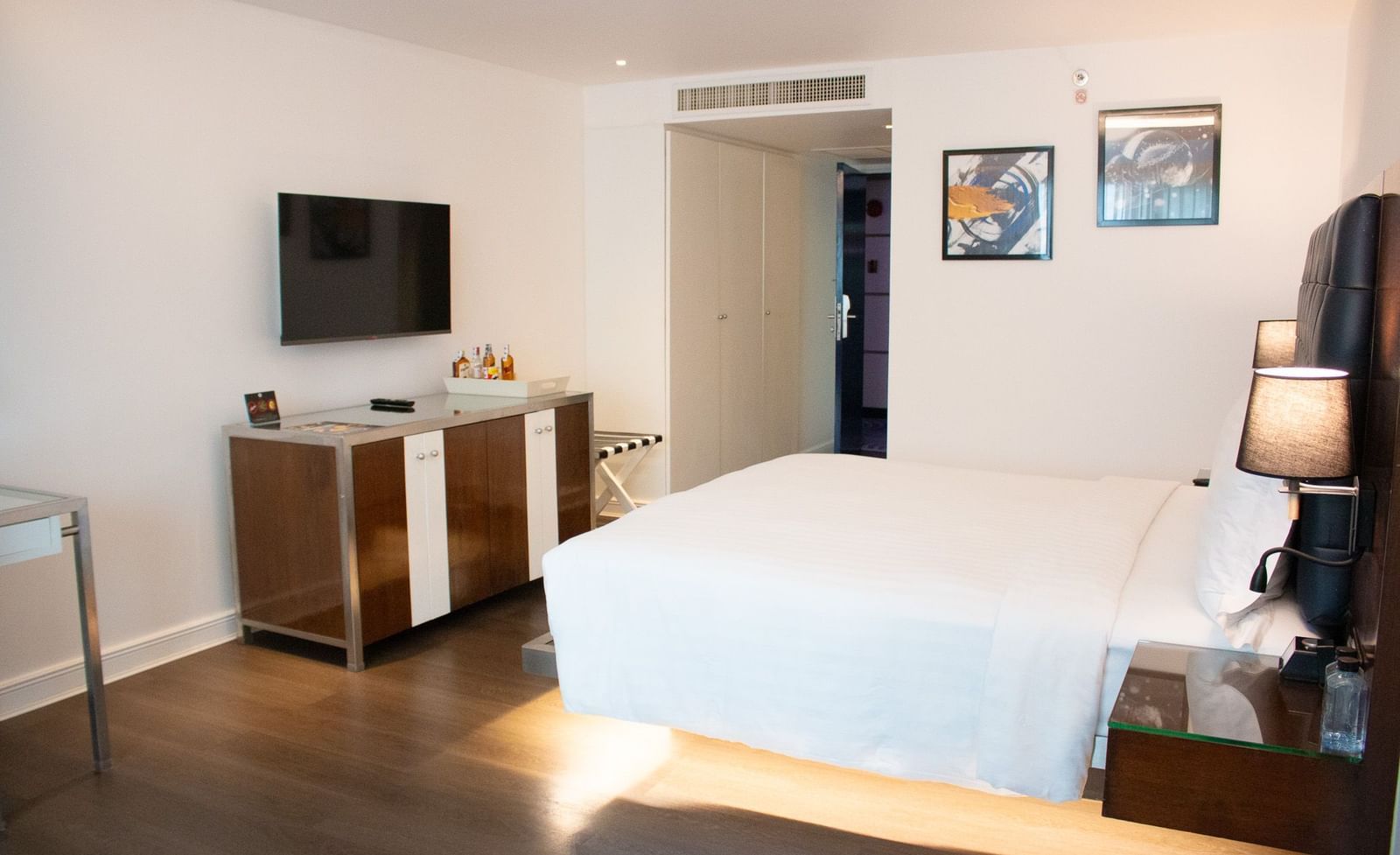 Guest room at Night Hotel Bangkok with king bed, TV, and bright natural lighting.
