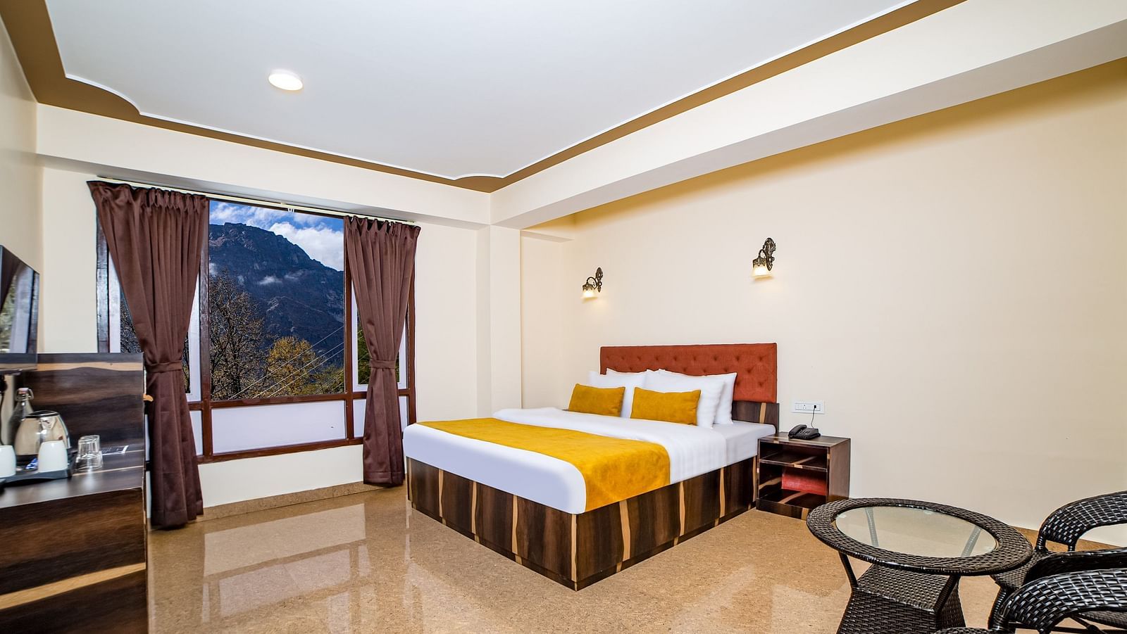 This inviting room at Sumitel Sonam Lachung offers a comfortable bed and a small table with chairs.