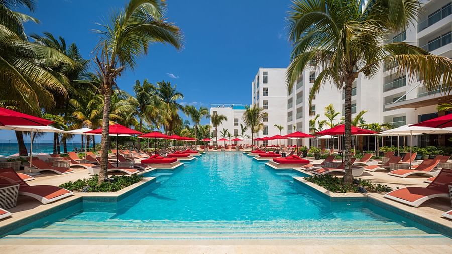 A wide-angle shot of a pool with red sun loungers on both sides - S Hotel Montego Bay, Jamaica