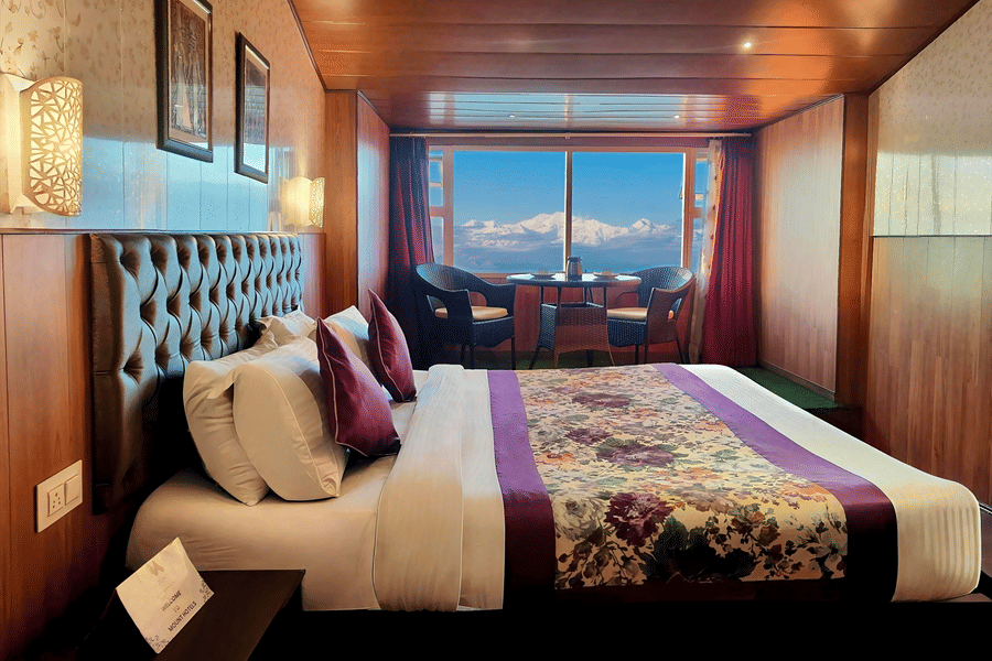 Bedroom with mountain views and warm wooden interiors at Mount Thistle Boutique Hotel, Darjeeling.