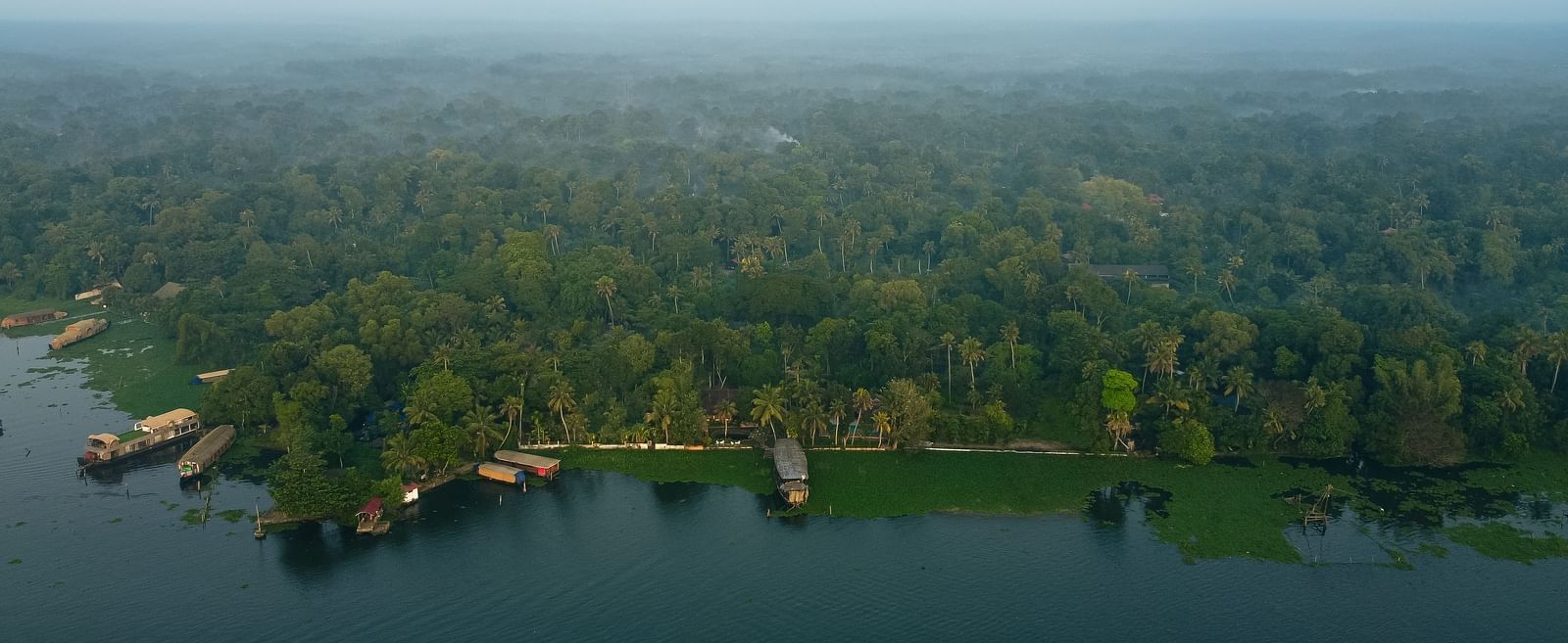An aerial shot of the resort surrounded by lush greenery and the Vembanad Lake in front - BluSalzz Villas - Muhamma Resort, Alleppey