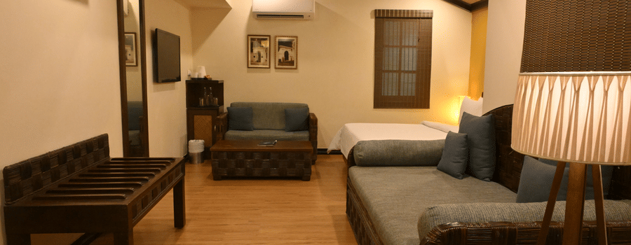 Sitting area at The Richmond Puducherry with couches, table and lamps.
